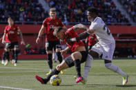 Real Madrid's Vinicius Junior, right, challenges for the ball with Mallorca's Pablo Maffeo during a Spanish La Liga soccer match between Mallorca and Real Madrid at the Son Moix stadium in Palma de Mallorca, Spain, Sunday, Feb. 5, 2023. (AP Photo/Francisco Ubilla)