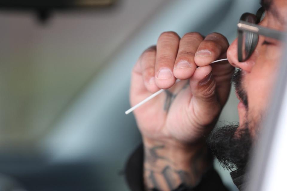 A man swabs his nose as part of a COVID-19 test on Wednesday, Feb. 2, 2022, in Las Cruces, N.M.