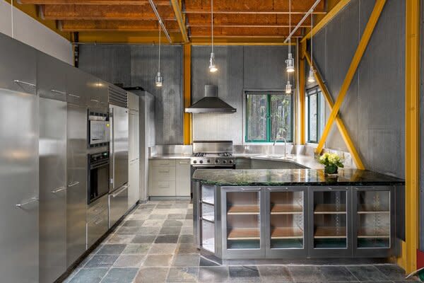 In the open kitchen, stainless-steel appliances blend in with the metal cabinetry.