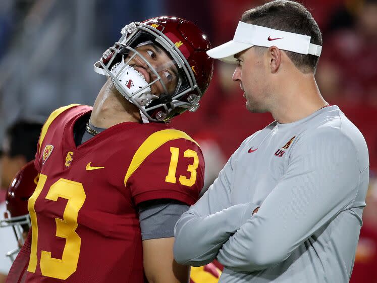 LOS ANGELES, CALIF. - OCT. 1, 2022. USC head coach Lincoln Riley talks with quarterback Caleb Williams before the game against Arizona State at the Los Angeles Memorial Coliseum on Saturday night, Oct. 1, 2022. (Luis Sinco / Los Angeles Times)