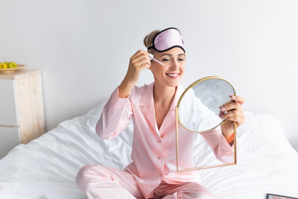 Woman-Applying-Face-Serum-Before-Bed-Stock-Photo