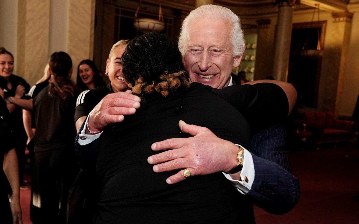 The King found himself in a royal scrum when he accepted a hug from the New Zealand women's rugby team during a Buckingham Palace reception on Wednesday