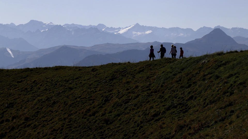 People make their way from the 'Kitzbuehler Horn' mountain (1,996 meters) at the alps near Kitzbuehl, Austria, Sunday, Oct. 27, 2019.(AP Photo/Matthias Schrader)