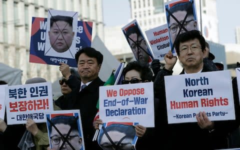 South Korean protesters and North Korean defectors hold portraits of North Korean leader Kim Jong-un during a rally urging the United States to discuss North Korean human rights issues - Credit: AP
