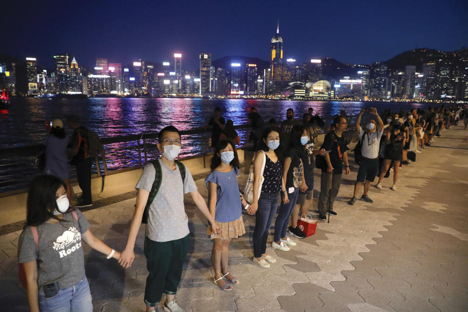 Demonstrators link hands as they gather at the Tsim Sha Tsui waterfront in Hong Kong, Friday, Aug. 23, 2019. Demonstrators were planning to form 40 kilometers (25 miles) of human chains Friday night to show their resolve. They said the "Hong Kong Way" was inspired by the "Baltic Way," when people in the Baltic states joined hands 30 years ago in a protest against Soviet control. (AP Photo/Vincent Yu)