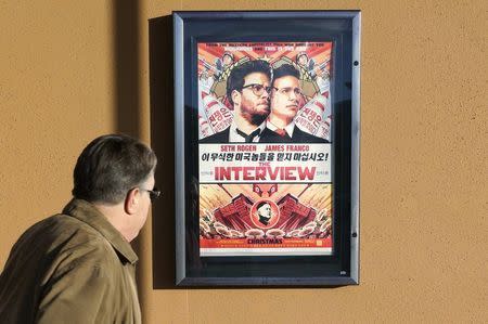 A man walks by the poster for the film "The Interview" outside the Alamo Drafthouse theater in Littleton, Colorado December 23, 2014. REUTERS/Rick Wilking