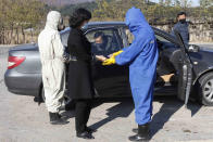 Hygienic and anti-epidemic officials disinfect and check the temperature of people coming into the city of Wonsan, Kangwon Province, North Korea DPRK, on Wednesday, Oct., 28, 2020. (AP Photo/Jon Chol Jin)