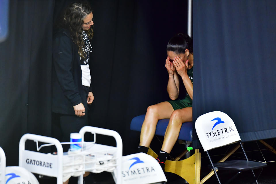 Sue Bird with a trainer on the sideline. 