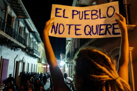 A demonstrator holds up a placard during the fourth day of protests calling for the resignation of Governor Ricardo Rossello in San Juan