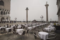 FILE - In this Feb. 25, 2020 file photo, empty tables sit in St. Mark's square in Venice, Italy. Still reeling from the effects of major flooding just a few months ago, Venice faces a new emergency: the threat of a new virus outbreak across Italy that is scaring international visitors world-wide and hitting the economy hard. (AP Photo/Renata Brito)