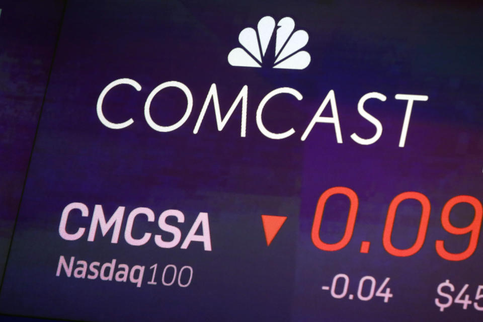 FILE - In this Oct. 1, 2019, file photo the symbol for Comcast appears on a screen at the Nasdaq MarketSite, in New York. Comcast Corp. reports financial earns on Thursday, Oct. 24, 2019. (AP Photo/Richard Drew, File)