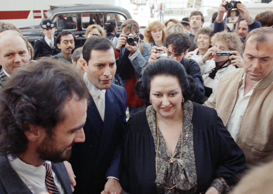 FILE - In this Monday, Oct. 10, 1988 file photo, rock star Freddie Mercury, center left, lead singer of the pop group Queen, arrives with opera star Montserrat Caballe at the Royal Albert Hall in London to publicize their hit song 'Barcelona.' Spanish opera diva Montserrat Caballe, renowned for her bel canto technique and her interpretations of the roles of Rossini, Bellini and Donizetti, has died. She was 85. Hospital Sant Pau press officer Abraham del Moral confirmed her passing away early on Saturday Oct. 6, 2018. (AP Photo/Martin Cleaver, File)
