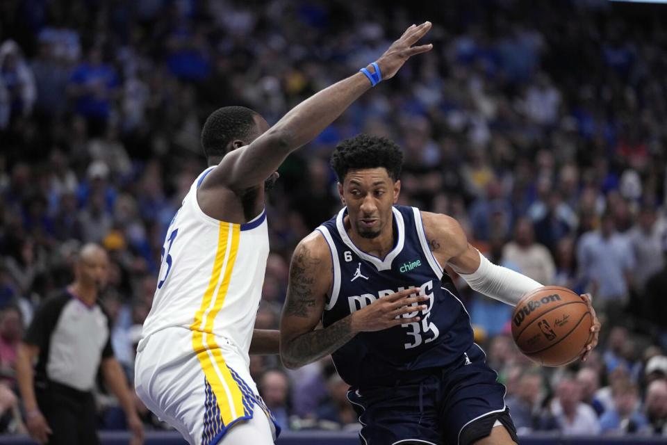 Dallas Mavericks forward Christian Wood works to the basket againt Golden State Warriors forward Draymond Green.