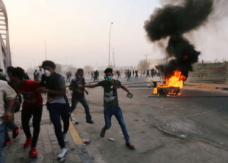 FILE PHOTO: Iraqi protesters run during a protest near the building of the government office in Basra, Iraq September 5, 2018. To match Analysis IRAQ-POLITICS/ REUTERS/Alaa al-Marjani/File Photo