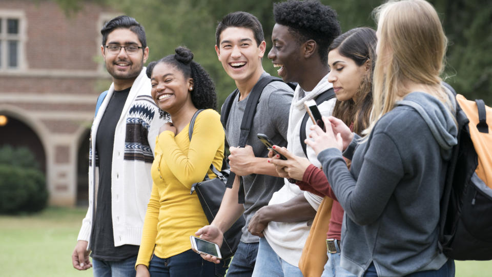 A few college friends walk on campus and chat with each other