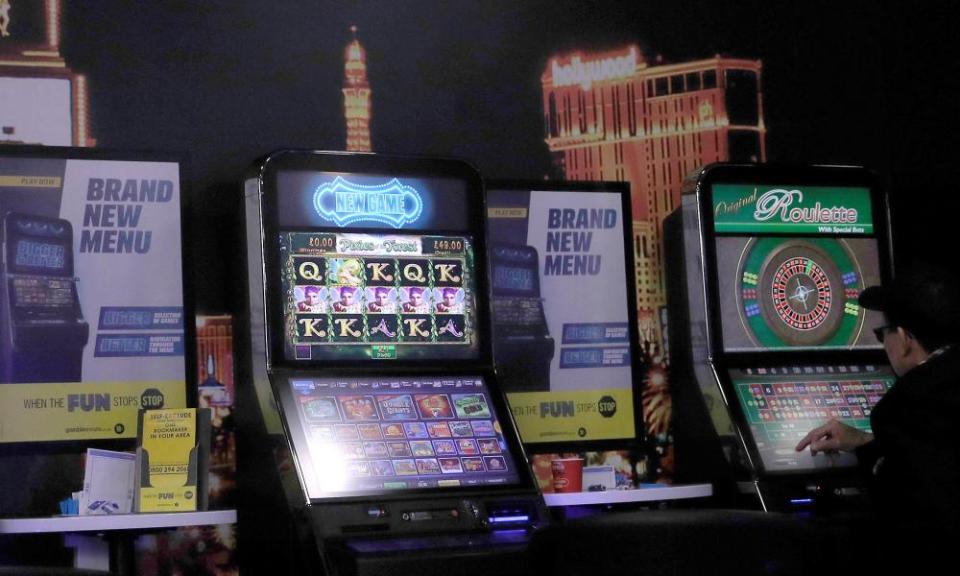 A man sits at a fixed- odds betting terminal