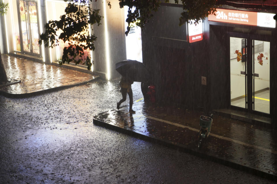 A resident walks through a rain storm in Nanchang in eastern China's Jiangxi province Tuesday, April 2, 2024. Violent rain and hailstorms have killed some people in eastern China's Jiangxi province this week, including people who fell from their apartments in a high-rise building. (Chinatopix Via AP) CHINA OUT