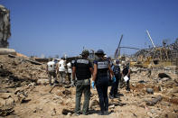 FILE - In this Aug. 8, 2020 file photo, French criminal police officers work on the site of this week's massive explosion in the port of Beirut, Lebanon For many Lebanese, their greatest hope for credible answers about the blast that wrecked much of their capital lies with outsiders. (AP Photo/Thibault Camus, File)