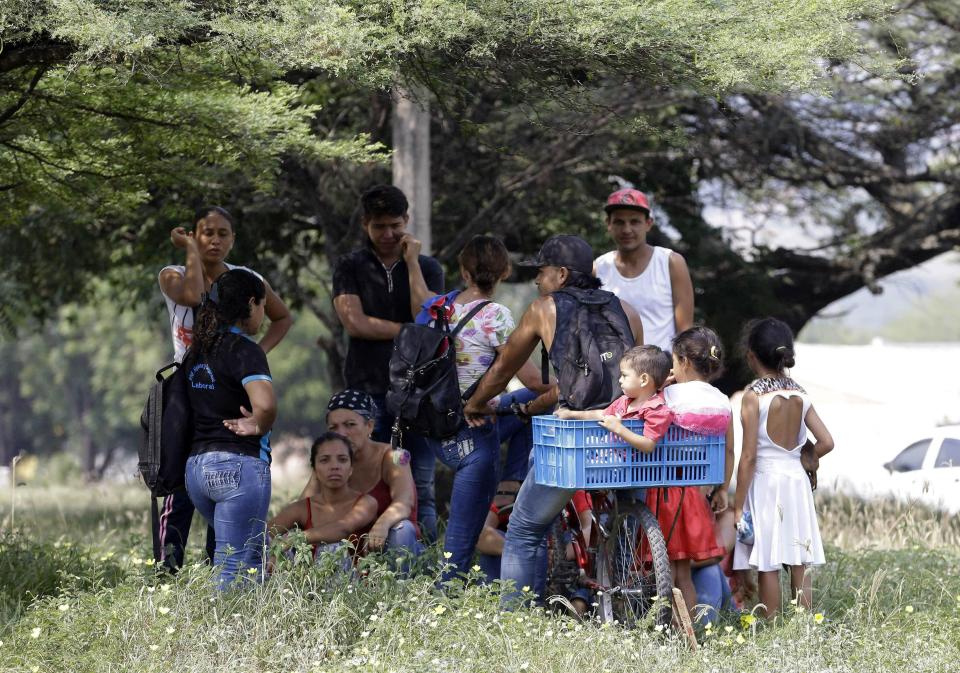 Venezuelan migrants rest under a tree near the International bridge Tienditas, on the outskirts of Cucuta, Colombia, on the border with Venezuela, Tuesday, Feb. 5, 2019. Venezuelan opposition leader Juan Guaido is moving ahead with plans to try to bring in humanitarian aid through the Colombian border city of Cucuta, where the U.S. government will transport and store food and medical supplies destined for Venezuela. (AP Photo/Fernando Vergara)