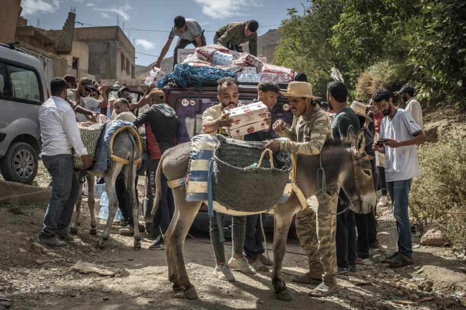 People load aid to donkeys to transport to hardly accessible houses in Douar Tnirt village in the Atlas Mountains in the hard-hit Al Haouz province on Sept. 10.<span class="copyright">Sergey Ponomarev—The New York Times/Redux</span>