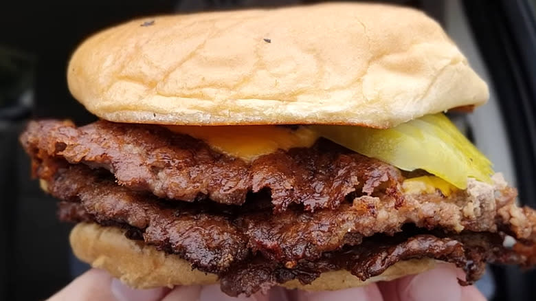 freddy's triple burger in hand