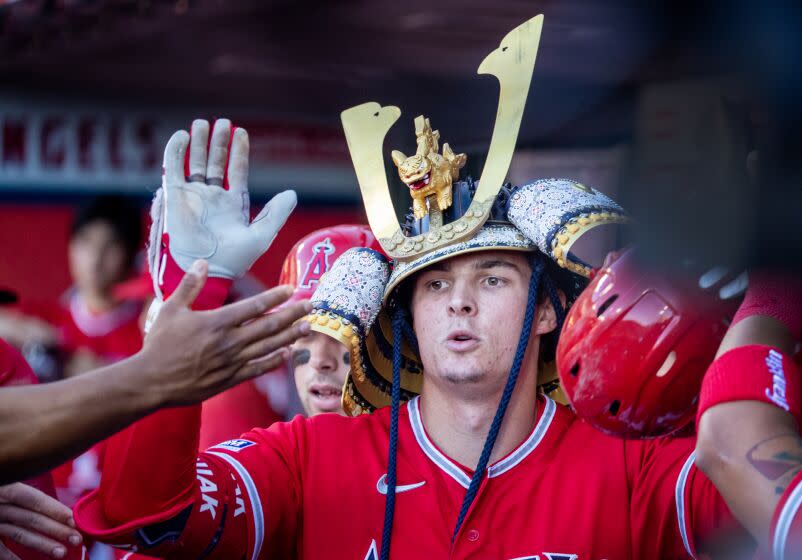 Anaheim, CA - July 18: Angels center fielder Mickey Moniak #16 is congratulated in the dugout.