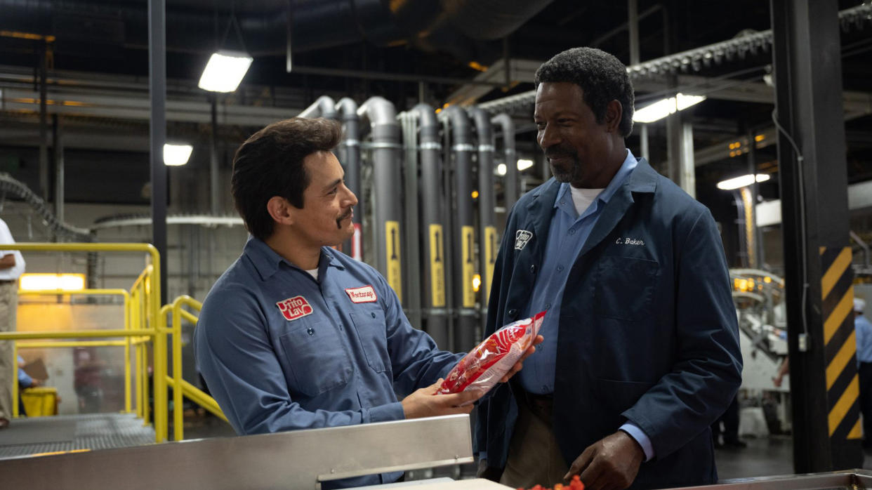  Two men hold a packet of Cheetos in Flamin Hot 