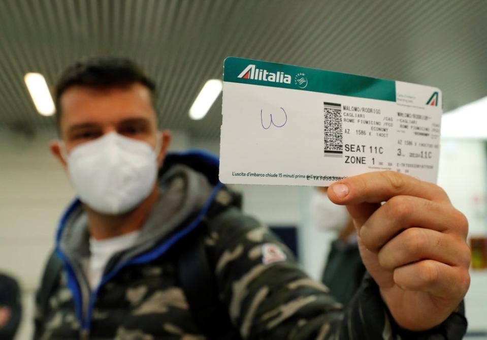 A passenger holds up a boarding pass from last ever Alitalia flight, AZ1586 from Cagliari to Rome (REUTERS)