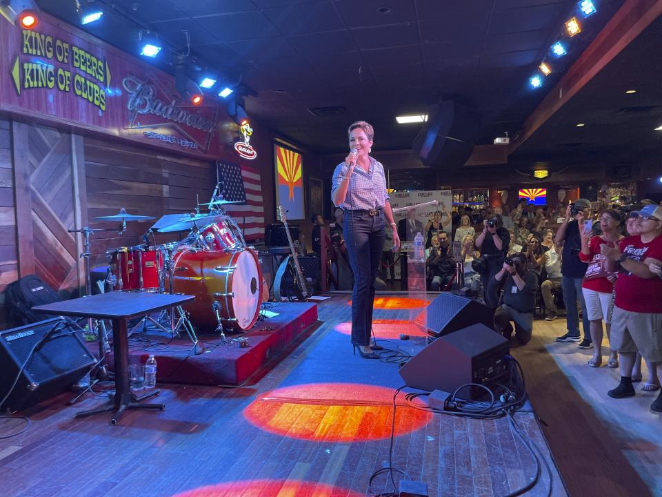 Kari Lake, a well-known former television news anchor now running for governor of Arizona, speaks to supporters at a country western bar in Tucson, Ariz., Tuesday, July 12, 2022. Establishment Republicans are working to lift up little-known housing developer Karrin Taylor Robson against Lake, who is backed by former President Donald Trump. (AP Photo/Jonathan J. Cooper)