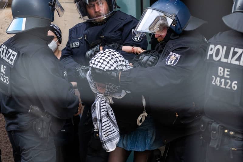 One of the pro-Palestinian occupiers of the Institute of Social Sciences at Berlin's Humboldt University (HU) is taken out of the building by police officers. Activists have occupied the university in support of the Palestinians and in protest against Israel. Christophe Gateau/dpa