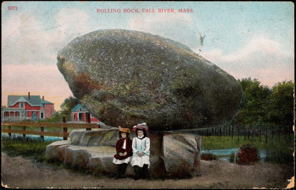 Two young girls sit under Fall River's Rolling Rock in this illustrated postcard from 1909.