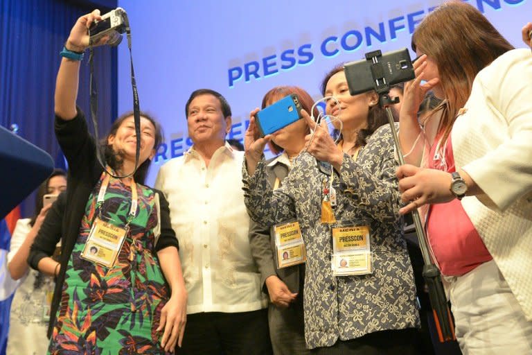 Philippines' President Rodrigo Duterte (2nd L) poses for selfie with journalists at the end of Association of Souteast Asian Nations (ASEAN) leaders' summit in Manila