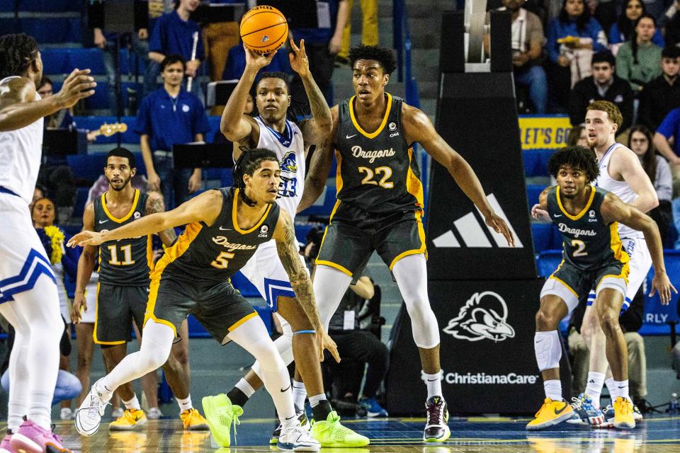 Delaware Fightin' Blue Hens forward Jy'are Davis (13) passes the ball against Drexel Dragons forward Amari Williams (22) and guard Kobe MaGee (5) during critical late-season NCAA basketball game at the Bob Carpenter Center in Newark, Monday, Feb. 26, 2024.