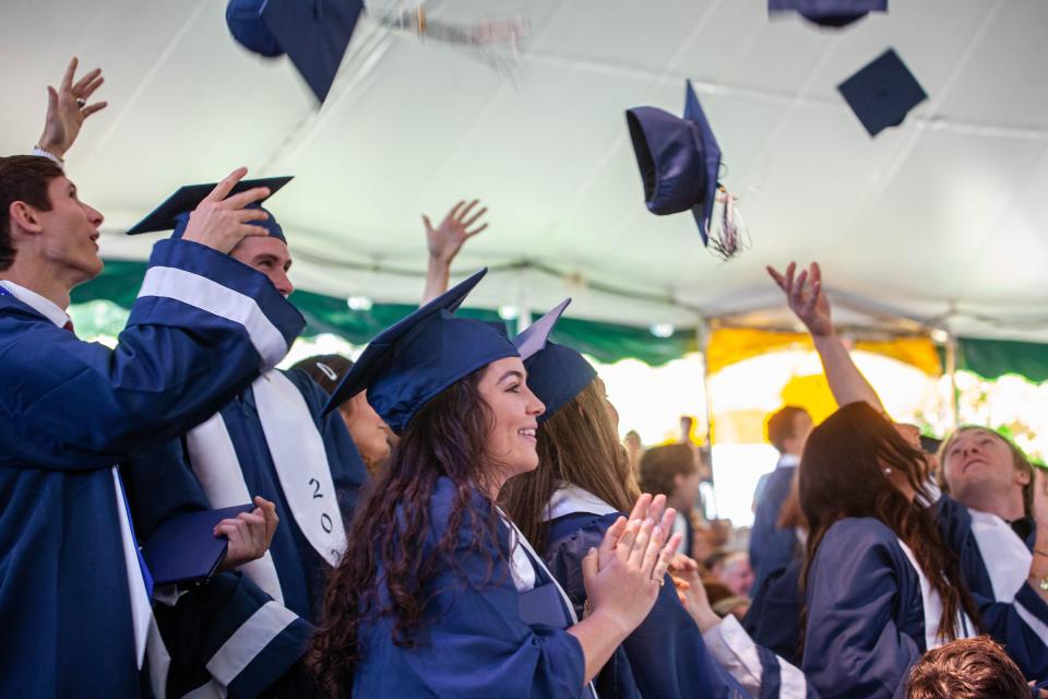 Graduates throw their mortarboards into the air during the Cohasset High School commencement at the South Shore Music Circus on Saturday, June 4, 2022.