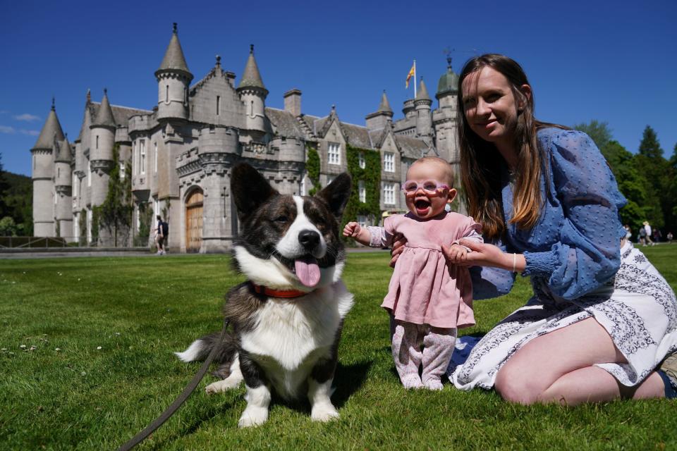 Charlotte Stephen and daughter Joy Stephen, 6 months, with their corgi Marvin on the front lawn at Balmoral during an event with the Corgi Society of Scotland (PA)