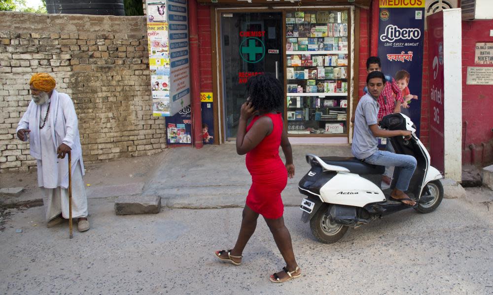 An African woman walks through a street in New Delhi.