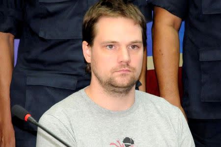 Hans Fredrik Lennart Neij, a co-founder of the Swedish file-sharing website, The Pirate Bay, is surrounded by policemen at the immigration office in Nong Khai province November 4, 2014. REUTERS/ Daily News