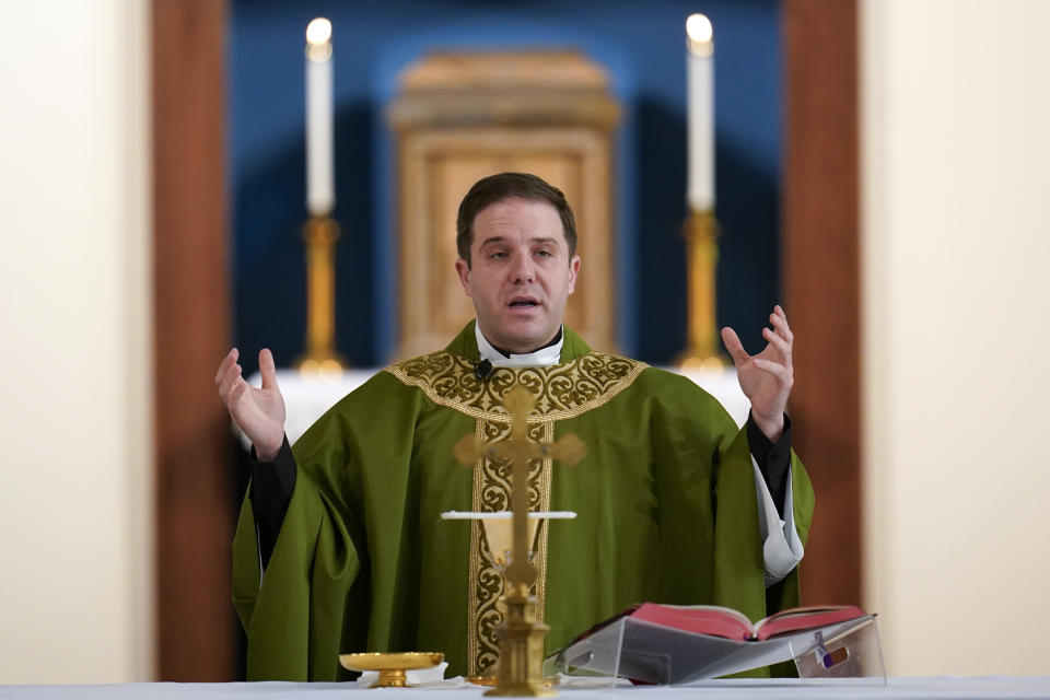 Father Matthew Hood celebrates mass at Our Lady of the Rosary church Friday, Feb. 18, 2022, in Detroit. In 2020, one word caught the ear of a young Detroit-area Catholic priest while he watched a video of his baptism from decades earlier. "Wait," the Rev. Matthew Hood recalled thinking. "Something doesn't seem right here." Indeed, an error by a deacon had spoiled the sacrament — and, in domino-like fashion, meant he truly wasn't a priest. (AP Photo/Paul Sancya)