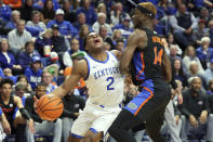 Kentucky's Sahvir Wheeler (2) is fouled by Florida's Kowacie Reeves (14) during the first half of an NCAA college basketball game in Lexington, Ky., Saturday, Feb. 4, 2023. (AP Photo/James Crisp)