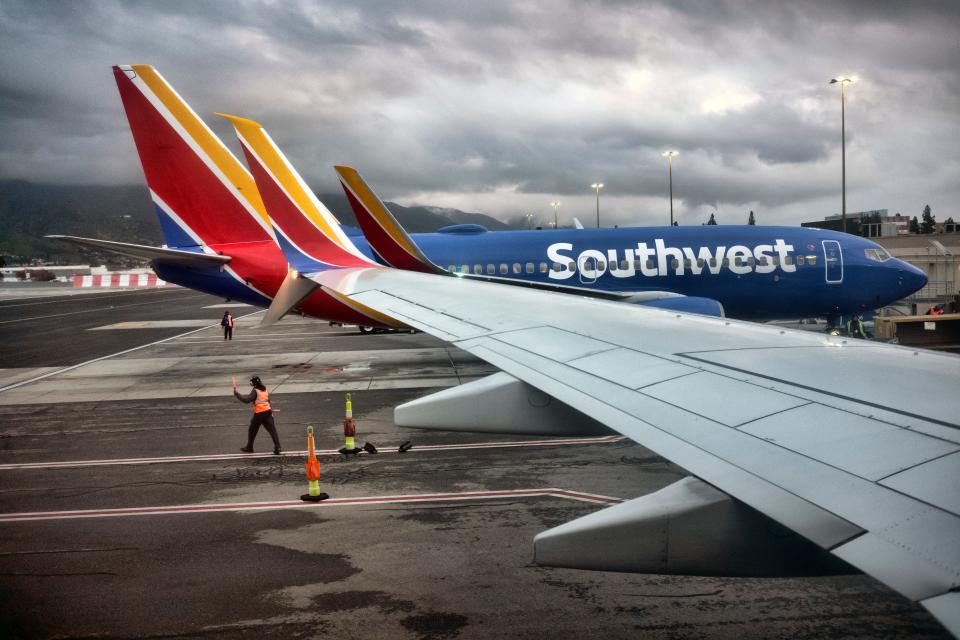 A Southwest Airlines ground crew directs a plane out of the terminal at Hollywood Burbank Airport in Burbank, Calif. on Tuesday, Feb. 14, 2023.