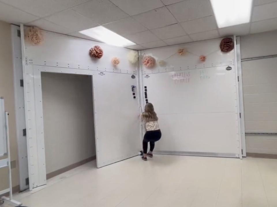 An Alabama teacher demonstrates the use of a whiteboard that can turn into a storm shelter and bulletproof safety room (Screenshot / Twitter / Gillian Brooks)