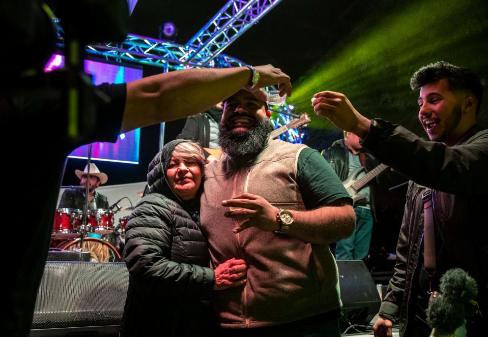 Organizer Angel Chavez embraces his mom, Maria Aguirre, as he and friends toast to celebrate Chavez's 30th birthday during Desert Underground in Coachella, Calif., Friday, Jan. 27, 2023.