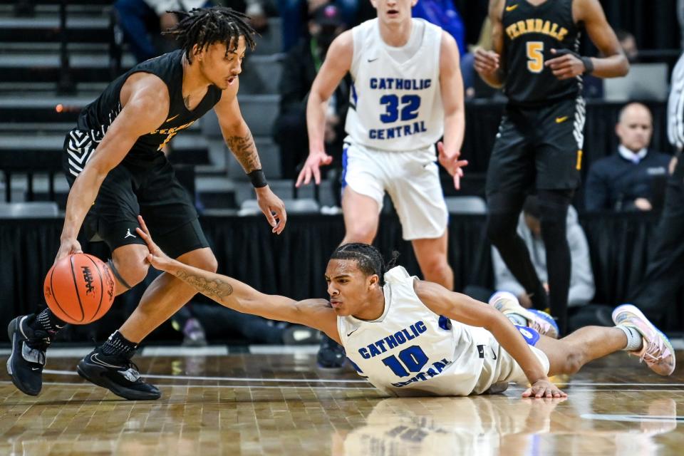 Grand Rapids Catholic Central's Durral Brooks, right, attempts to steal the ball from Ferndale's Jason Drake Jr. during the first quarter in the Division 2 state semifinal game on Friday, March 25, 2022, at the Breslin Center in East Lansing.