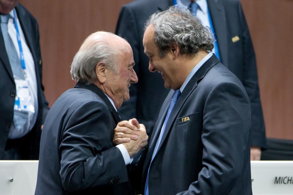 FIFA President Joseph S. Blatter (L) shakes hands with UEFA president Michel Platini during the 65th FIFA Congress at Hallenstadion