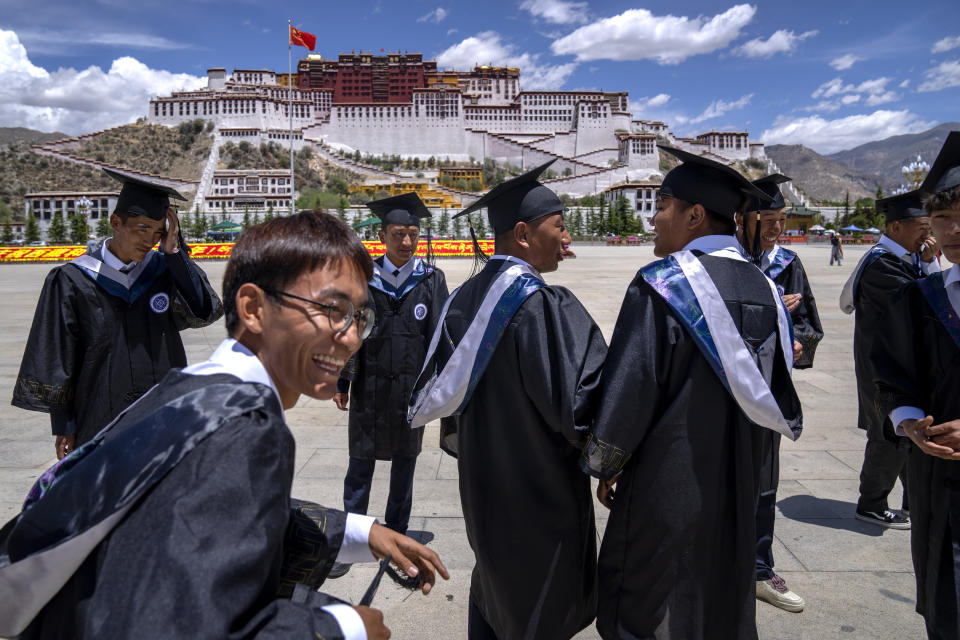 Graduates of the College of Science of Tibet University gather to pose for a group photo at the base of the Potala Palace in Lhasa in western China's Tibet Autonomous Region, as seen during a rare government-led tour of the region for foreign journalists, Tuesday, June 1, 2021. Long defined by its Buddhist culture, Tibet is facing a push for assimilation and political orthodoxy under China's ruling Communist Party. (AP Photo/Mark Schiefelbein)