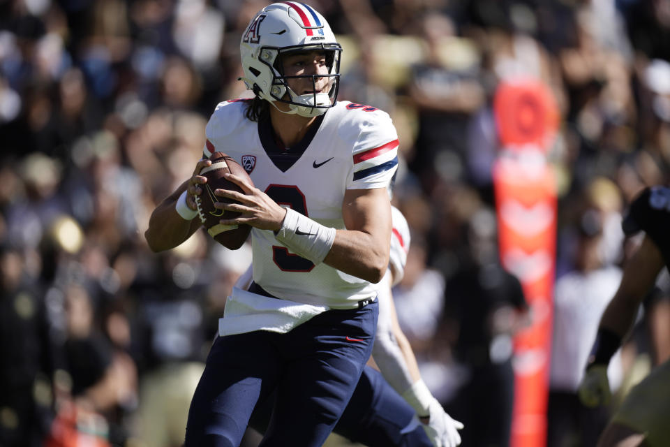Arizona quarterback Gunner Cruz rolls out to pass the ball against Colorado in the first half of an NCAA college football game Saturday, Oct. 16, 2021, in Boulder, Colo. (AP Photo/David Zalubowski)