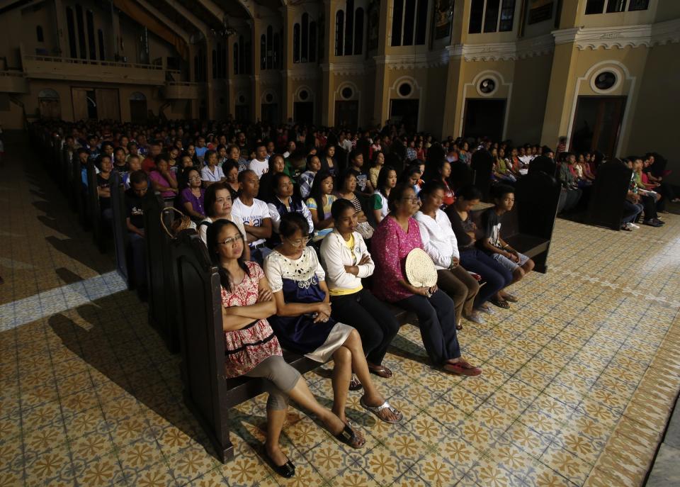 Typhoon Haiyan survivors take part in the first out of nine days of Christmas vigil masses at a damaged church in Palo, Leyte, central Philippines December 16, 2013. More than a month after super typhoon Haiyan lashed central Philippines, bodies are still being recovered with the death toll now at over 6,000, nearly 1800 others missing and around 4 million people displaced, government disaster agency said. REUTERS/Erik De Castro (PHILIPPINES - Tags: DISASTER RELIGION)