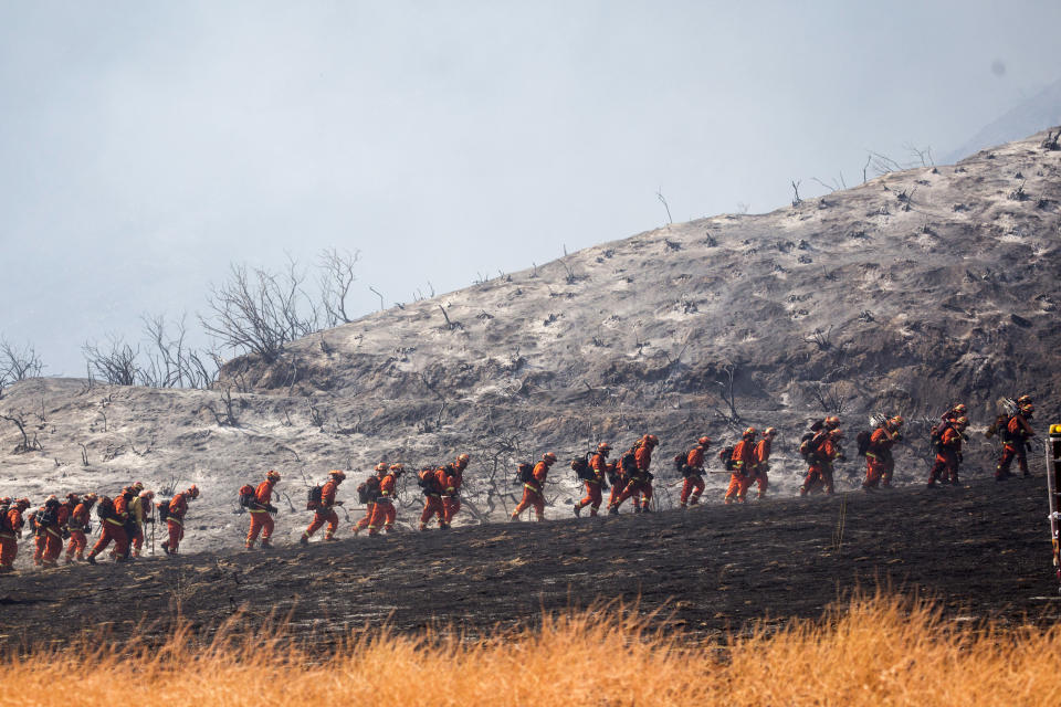 FILE - In this Sept. 5, 2020, file photo, members of a hand crew work on the fire line in Yucaipa, Calif. Two unusual weather phenomena combined to create some of the most destructive wildfires the West Coast states have seen in modern times. (AP Photo/Ringo H.W. Chiu, File)