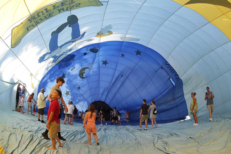 Families walk inside the Little Miss Muffet hot-air balloon Saturday at the balloon education area of the Pro Football Hall of Fame Enshrinement Festival Balloon Classic.