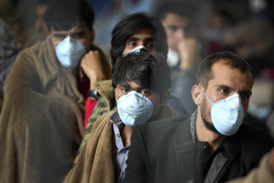 People wait for their departure at a hangar of the Ramstein U.S. Air Base in Ramstein, Germany, Monday, Aug. 30, 2021. The largest American military community overseas houses thousands Afghan evacuees in a tent city at the airbase. (AP Photo/Matthias Schrader)